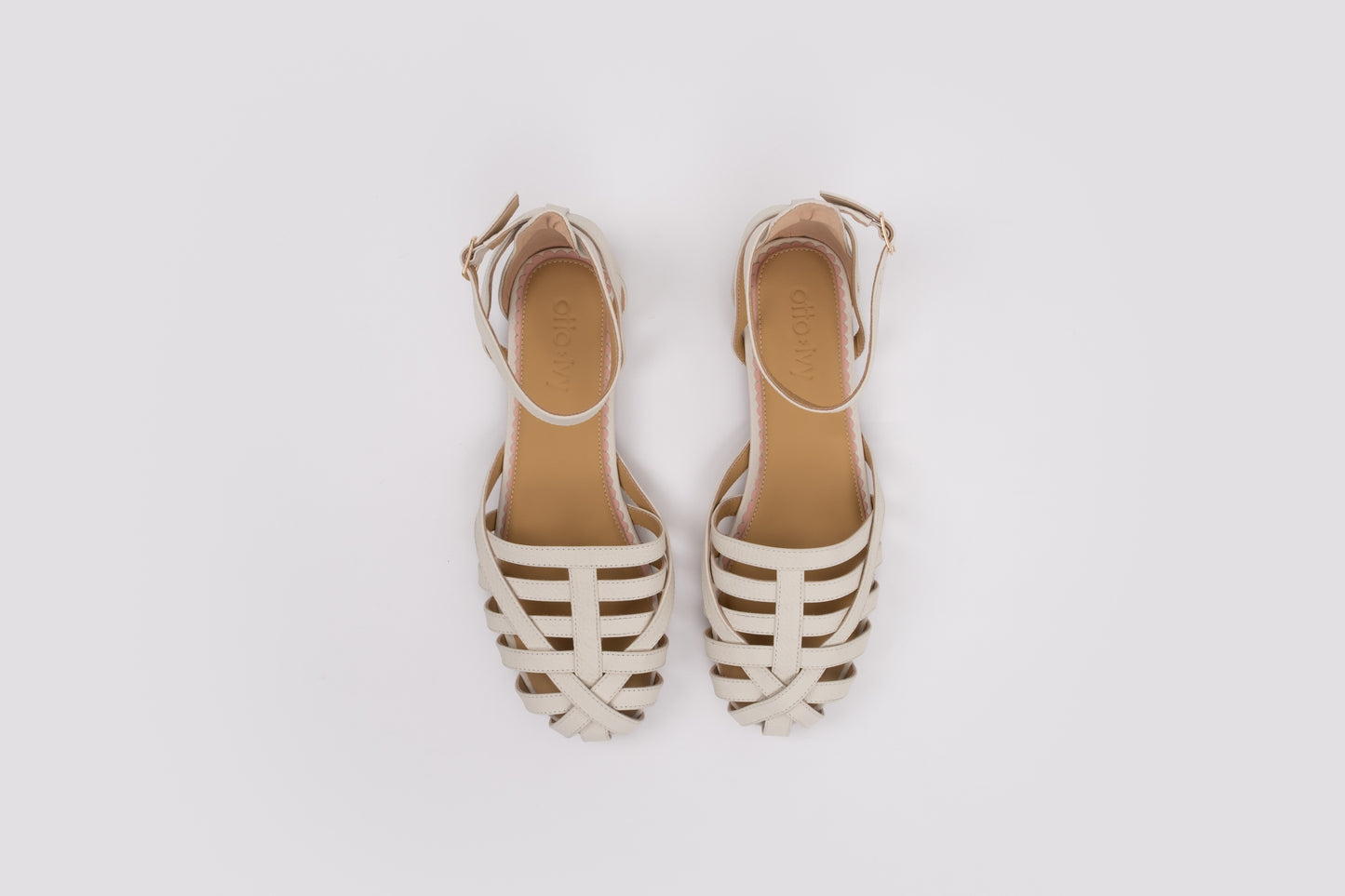 size 10 womens Pair of beige sandals with white stripes on a light gray background