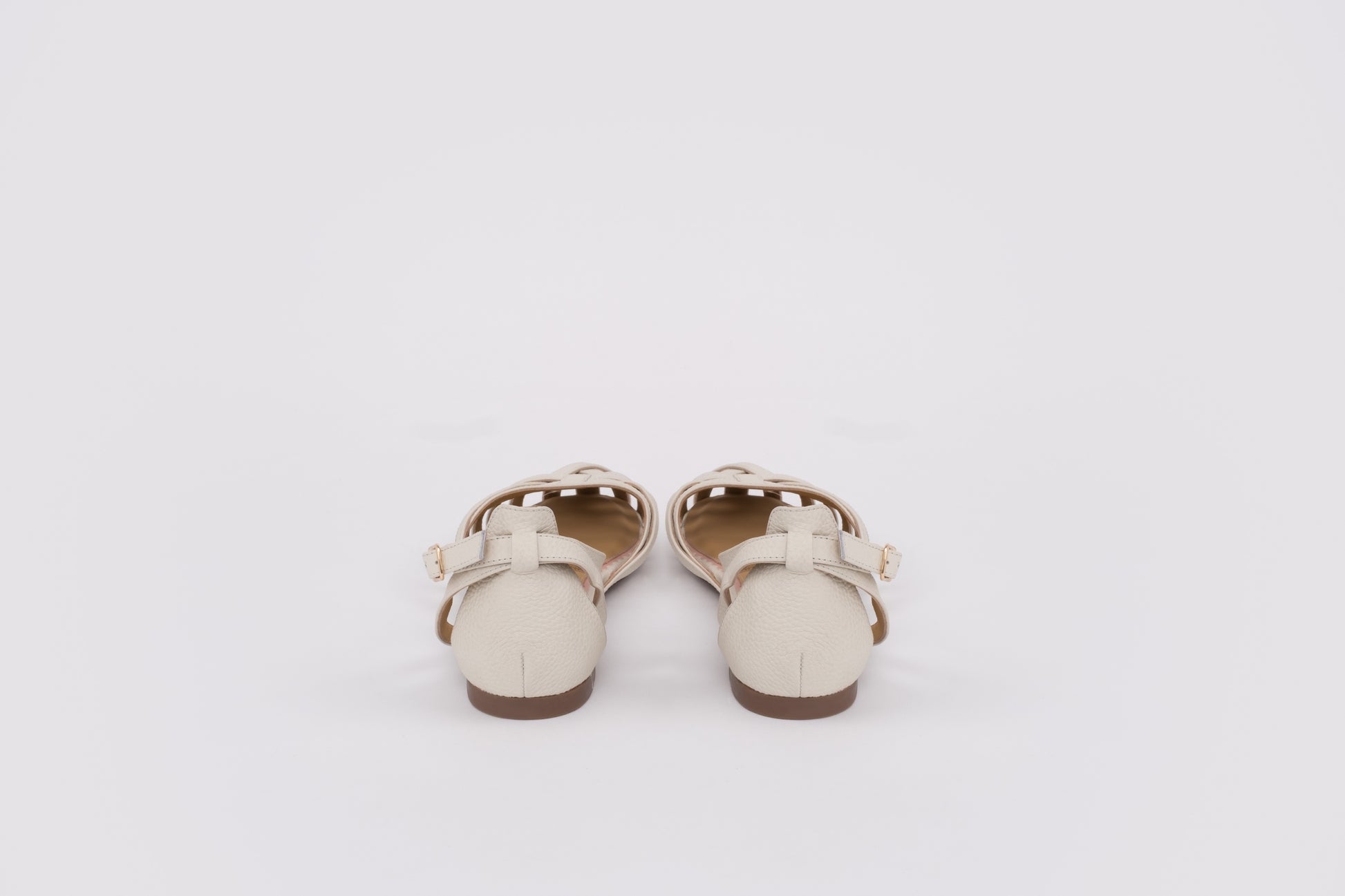 large sized womens Pair of white sandals with brown soles on a light gray background