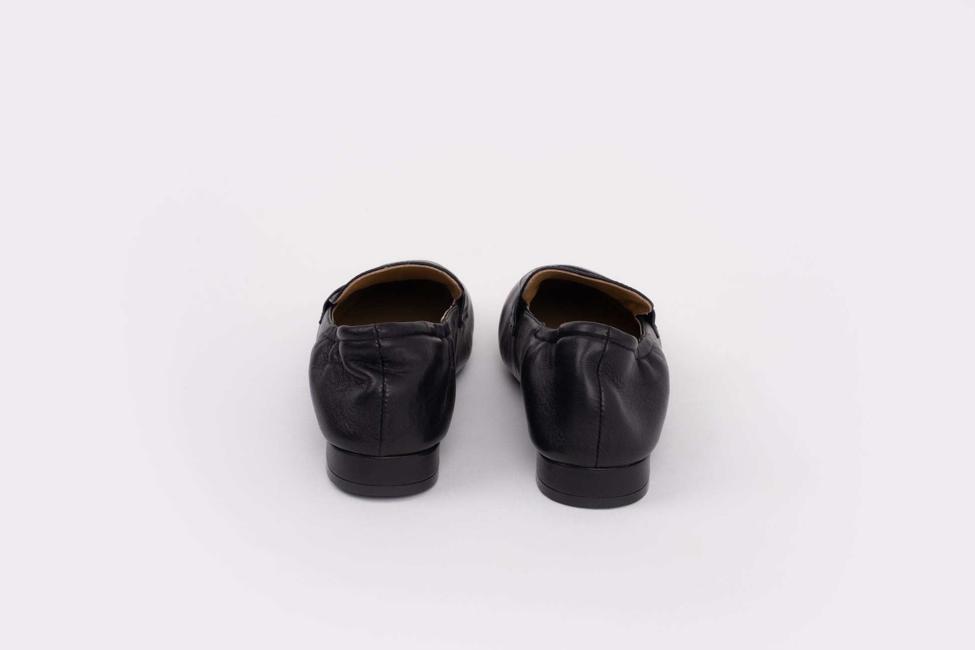 Pair of large sized 9 womens black leather shoes on a white background
