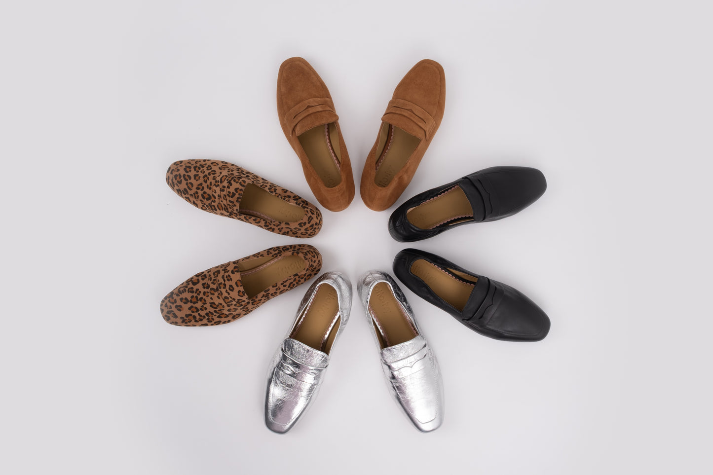 Set of loafers in various colors arranged in a circle on a light gray background