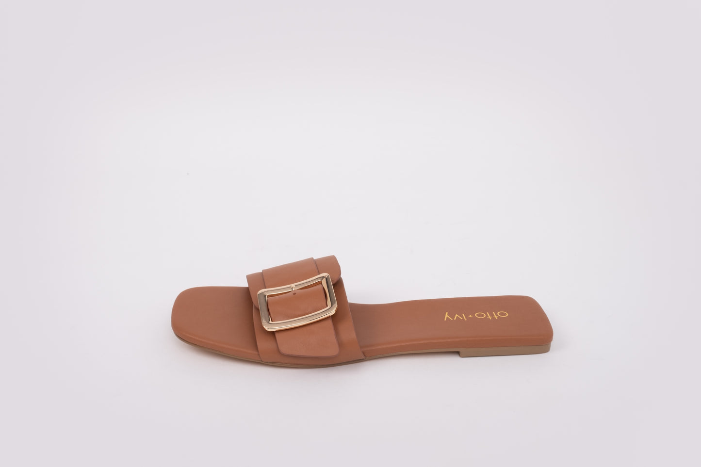 Side profile of womens slide on sandal Ruby in tan. with buckle in larger sizes from 42-46