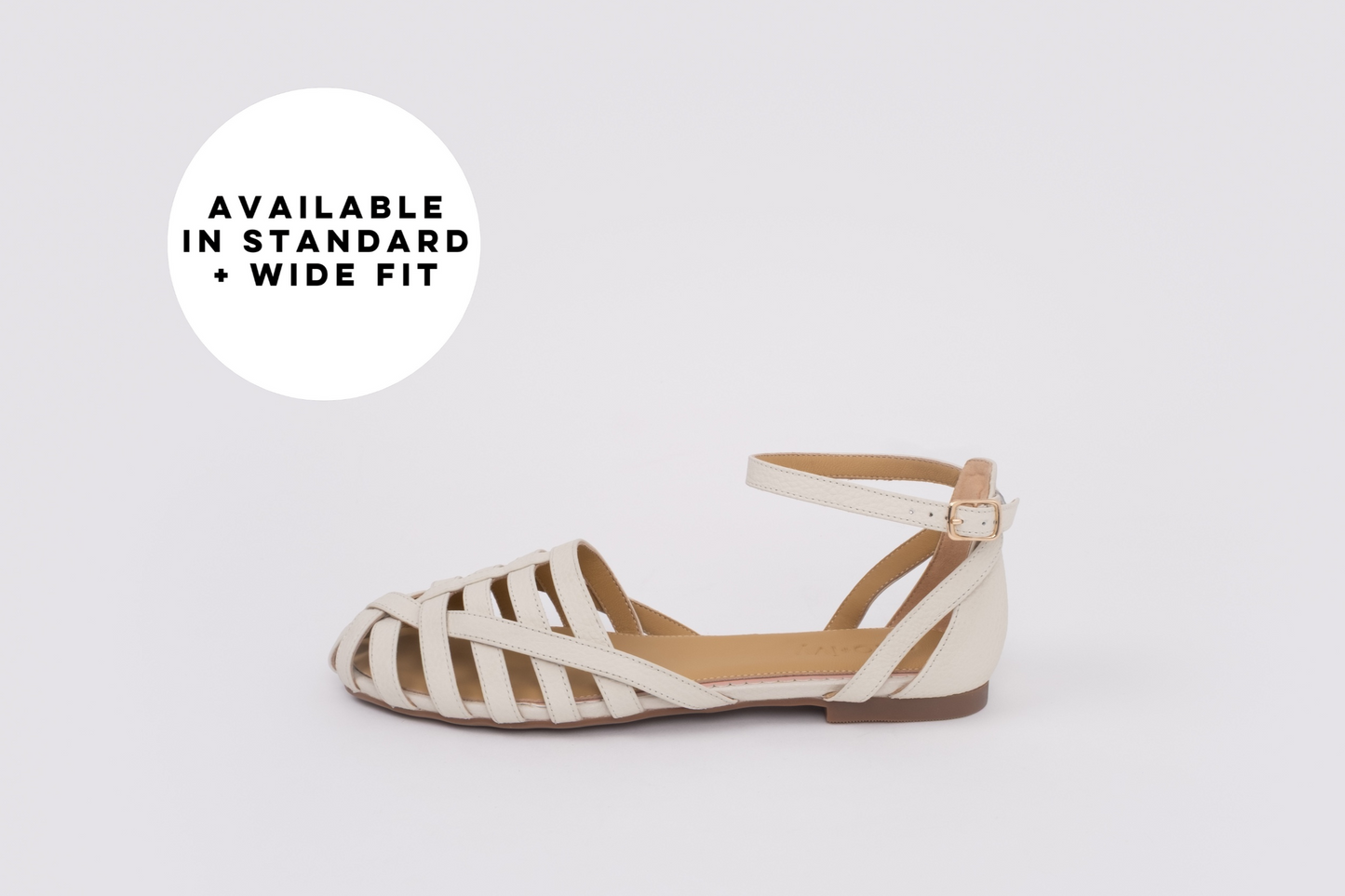 Womens large sized flat shoe on a light gray background with text 'Available in Standard + Wide Fit'.