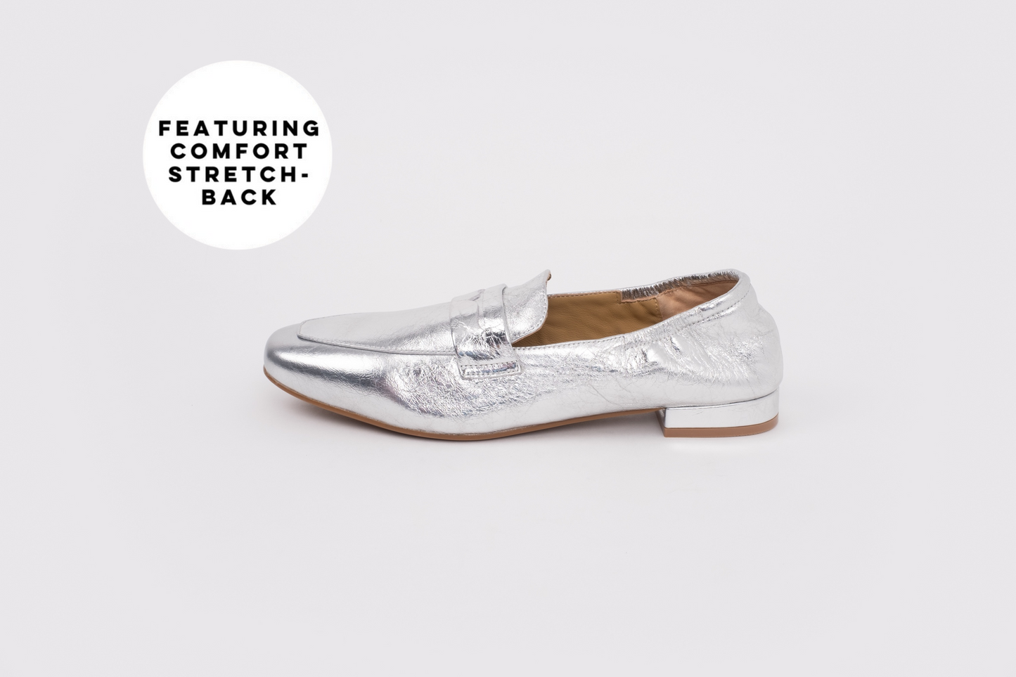Large sized womens Silver loafer shoe on a white background with text 'Featuring Comfort Stretch'.