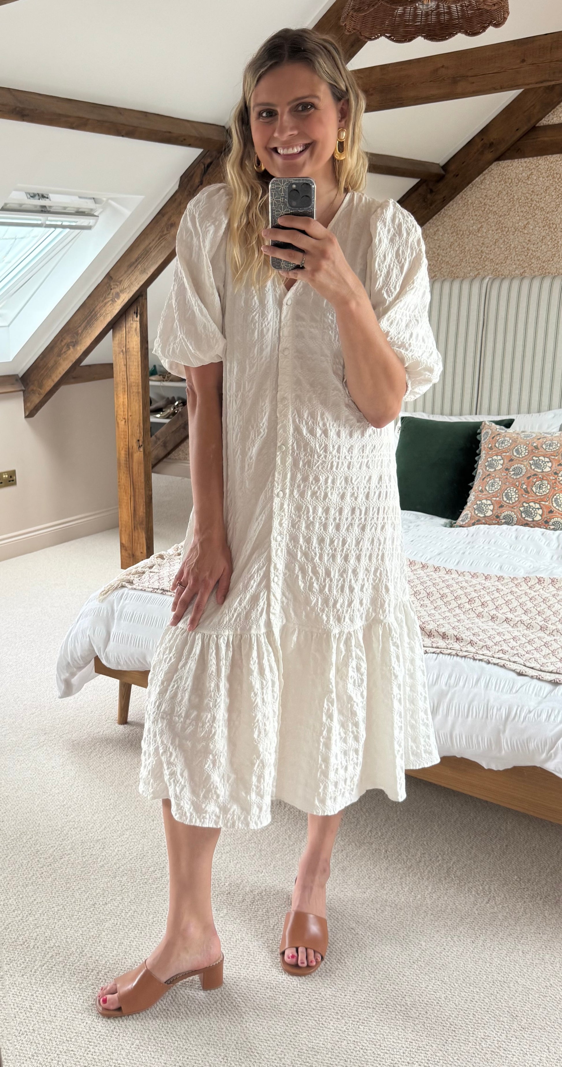 Woman taking a mirror selfie wearing a white dress in a bedroom and tan heeled leather sandals in uk size 9