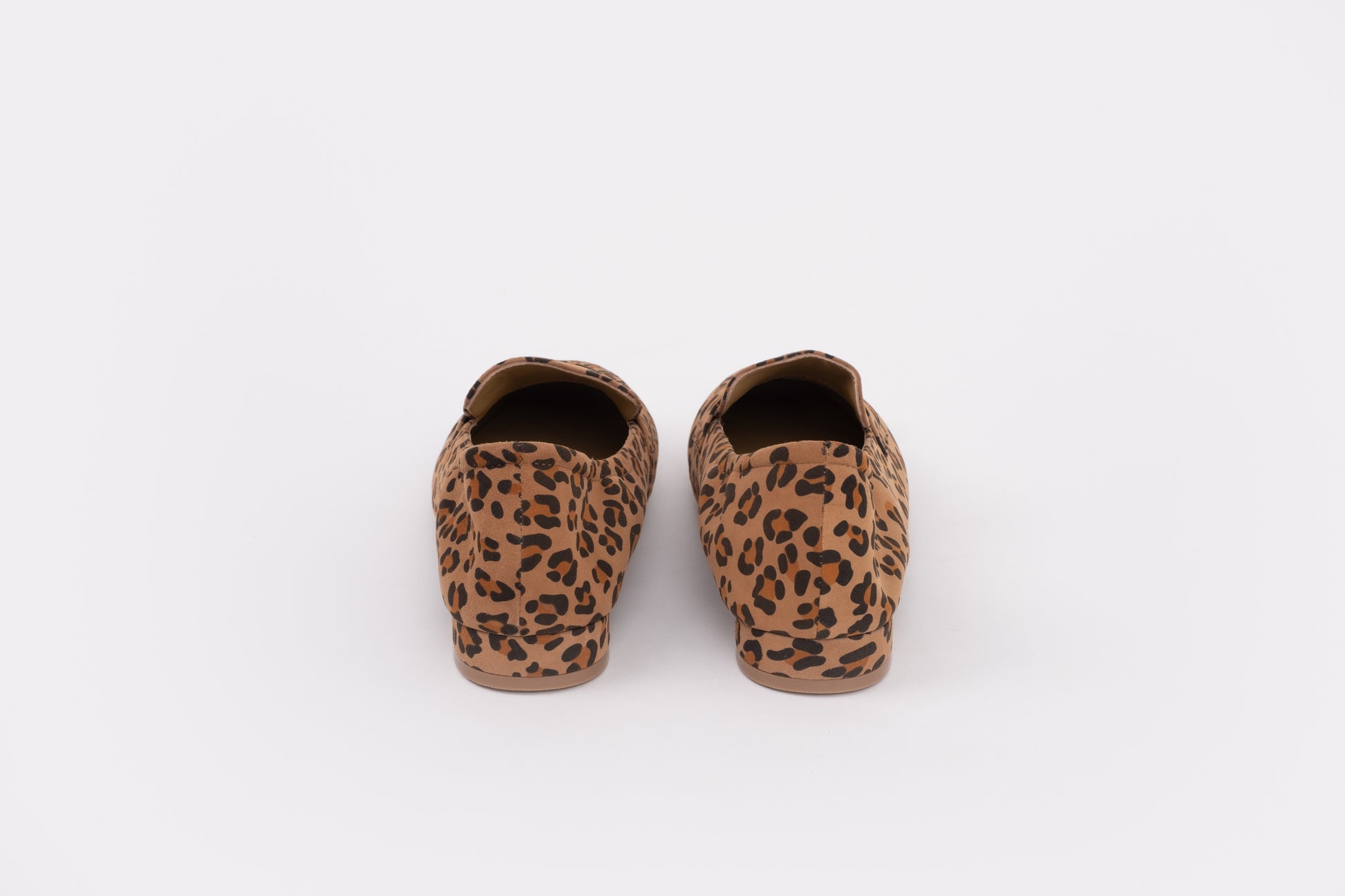 Back shot of womens size 9 large sized Pair of leopard print slippers on a white background
