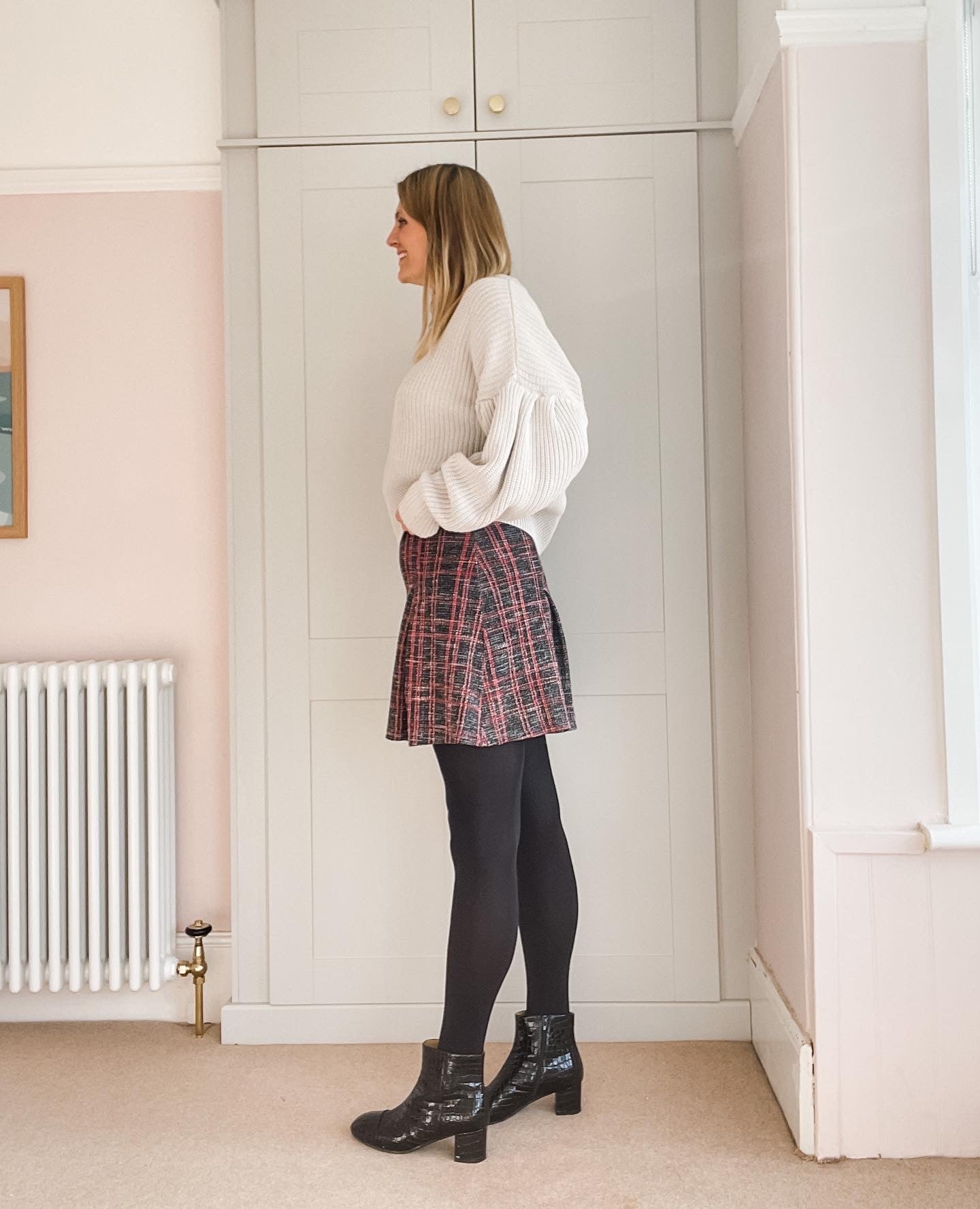 Izzy Boot by Otto + Ivy - a side profile of a black boot for tall women with large feet, featuring glossy black croc leather and a low chunky heel, being worn by a model wearing a tartan skirt and beige jumper and tights.
