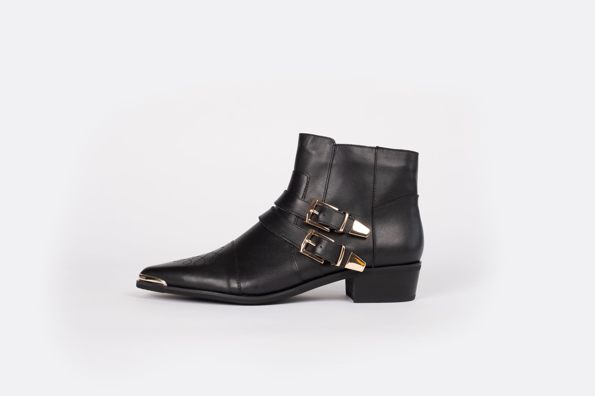 A side profile of the Otto + Ivy black Tilly Boot, a western style ankle boot for tall women with large feet, featuring gold buckles and hardware.